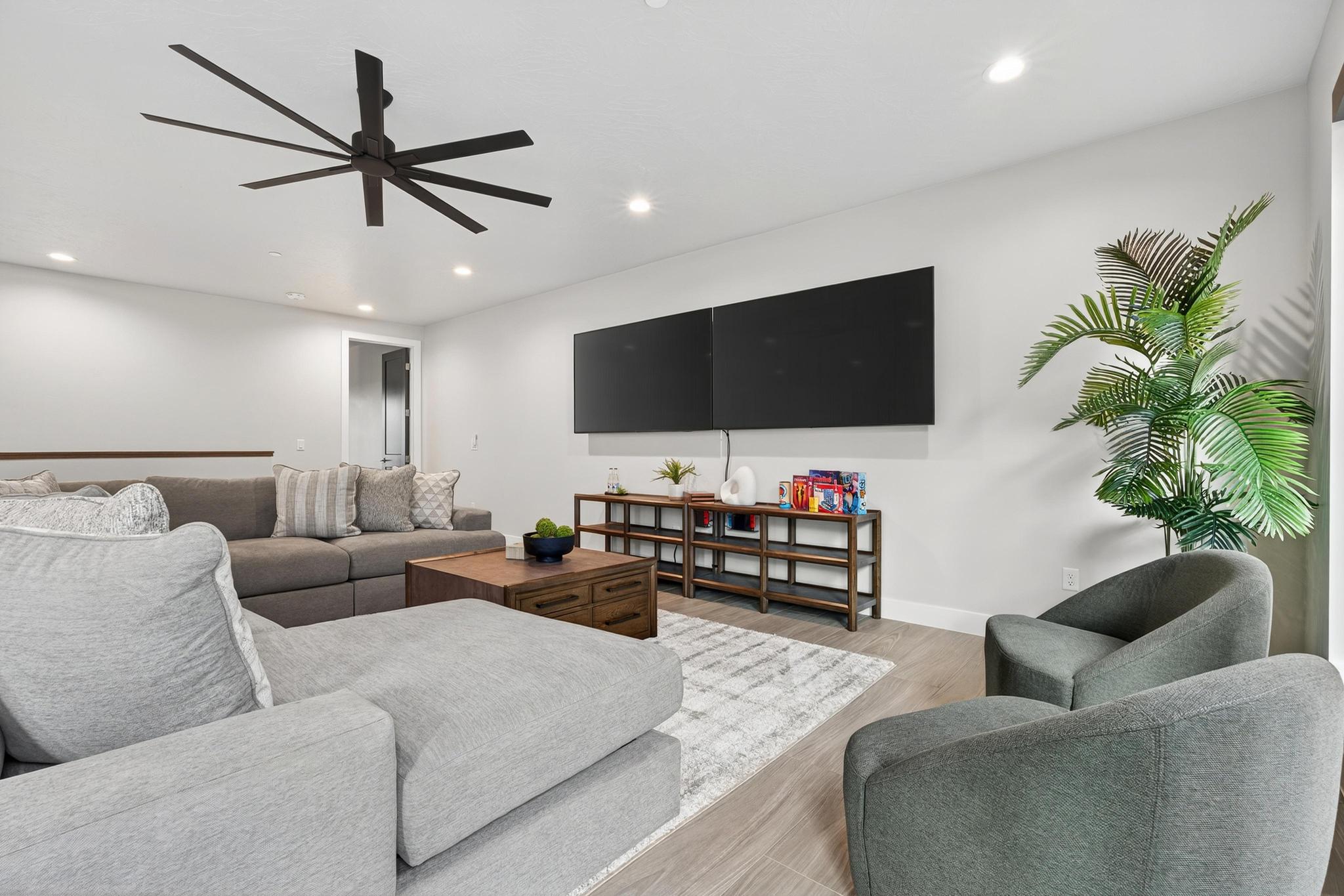 Living area with wood finished floors, a ceiling fan, and recessed lighting