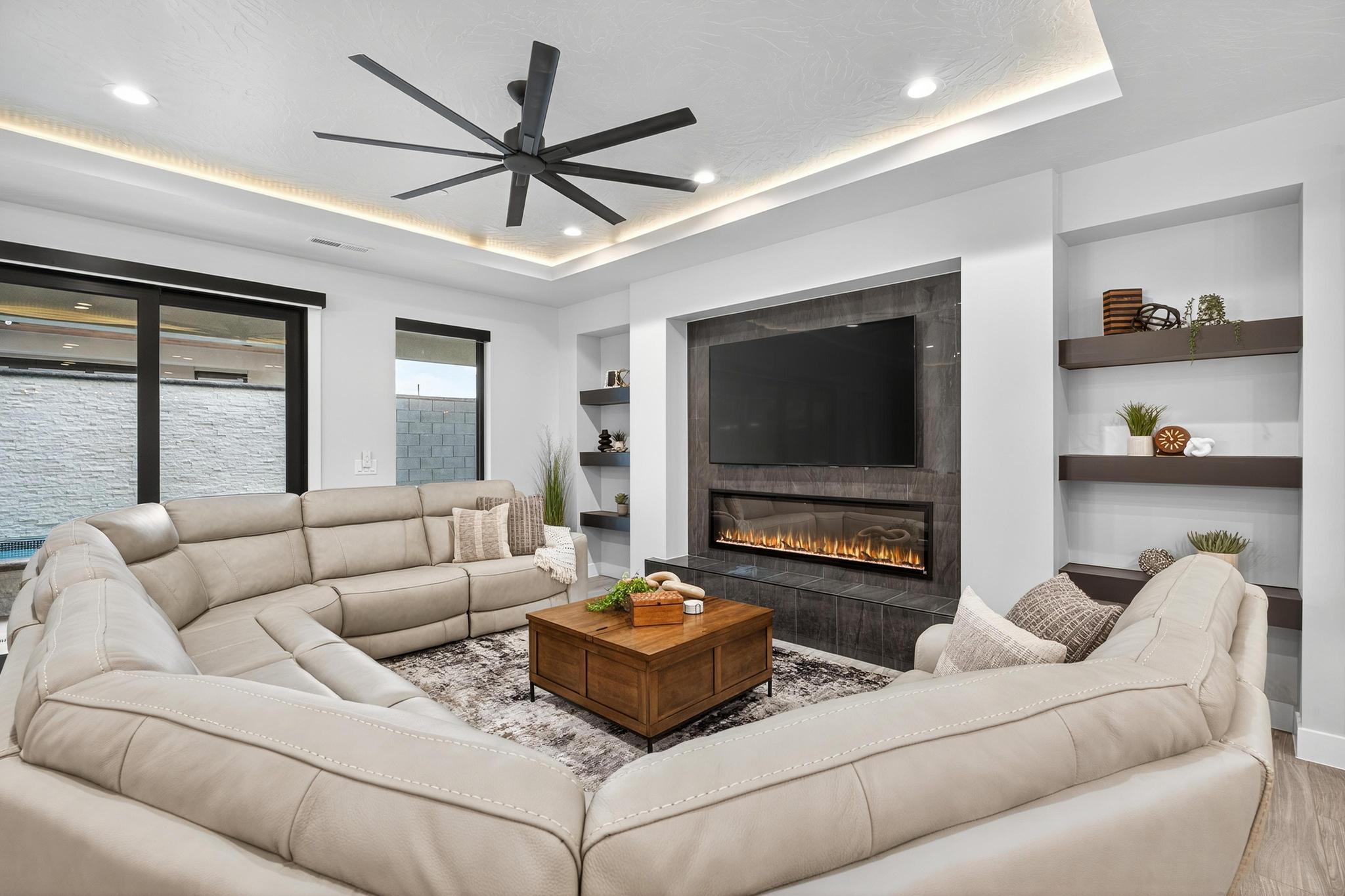 Living room featuring built in features, a tile fireplace, ceiling fan, recessed lighting, and wood finished floors