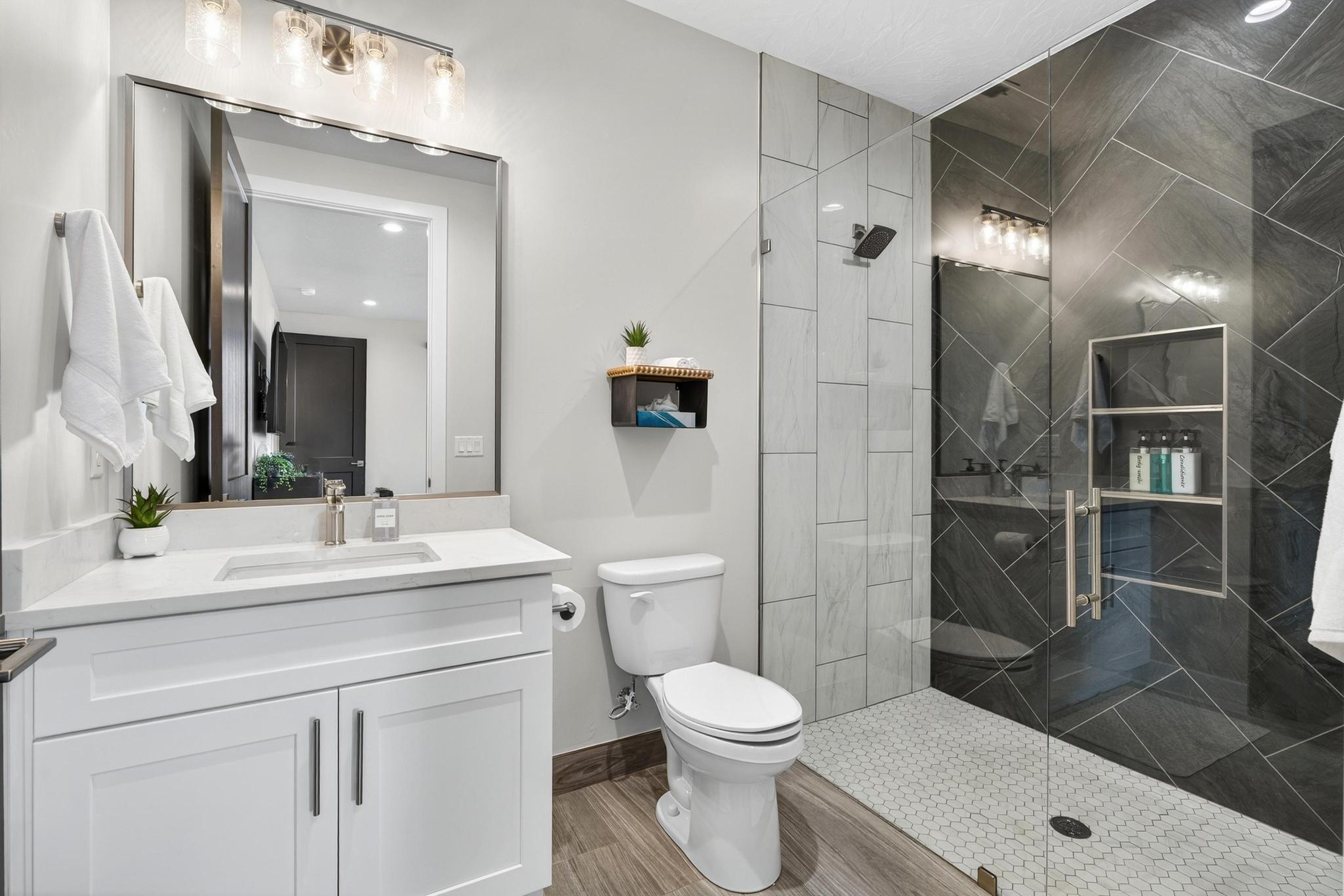 Full bath featuring vanity, a marble finish shower, and recessed lighting
