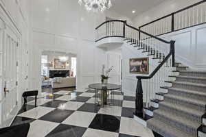 Exquisite and elegant foyer entrance with vaulted ceiling, stunning chandelier and a grand sweeping staircase.