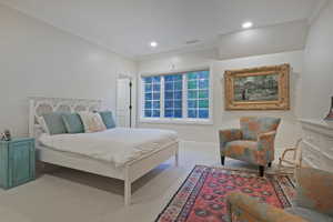 Spacious ensuite bedroom with ornamental molding, light colored carpet, and recessed lighting