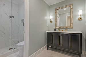 Elegant bathroom with crown molding, vanity, light marble finish flooring, and a marble finish shower