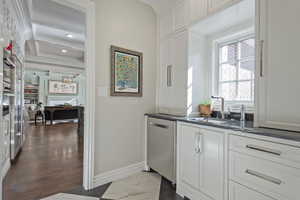 Butlers pantry with cabinetry, extra stainless steel appliances, sink and hidden appliance garages.