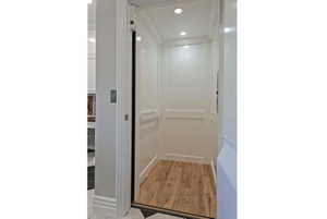 Elevator with ornamental molding, recessed lighting, and wood finished floors