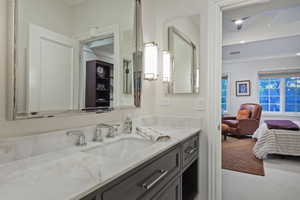 Bathroom featuring ornamental molding, single vanity, and connected ensuite