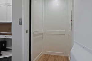 Elevator with wood finished floors and an office area - services 1-2 floors.
