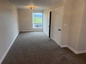 Empty room featuring carpet and baseboards