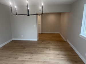 Unfurnished dining area with light wood-style floors and a chandelier