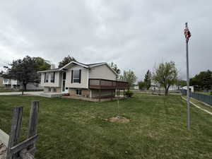View of side of home with a chimney, a wooden deck, and brick siding
