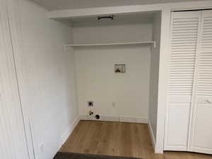 Laundry area featuring wood finished floors, hookup for a washing machine, and electric dryer hookup
