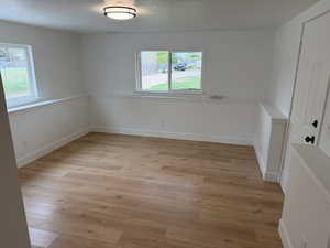 Unfurnished dining area with a textured ceiling and light wood-style floors