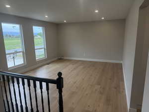 Empty room with recessed lighting and light wood-style flooring