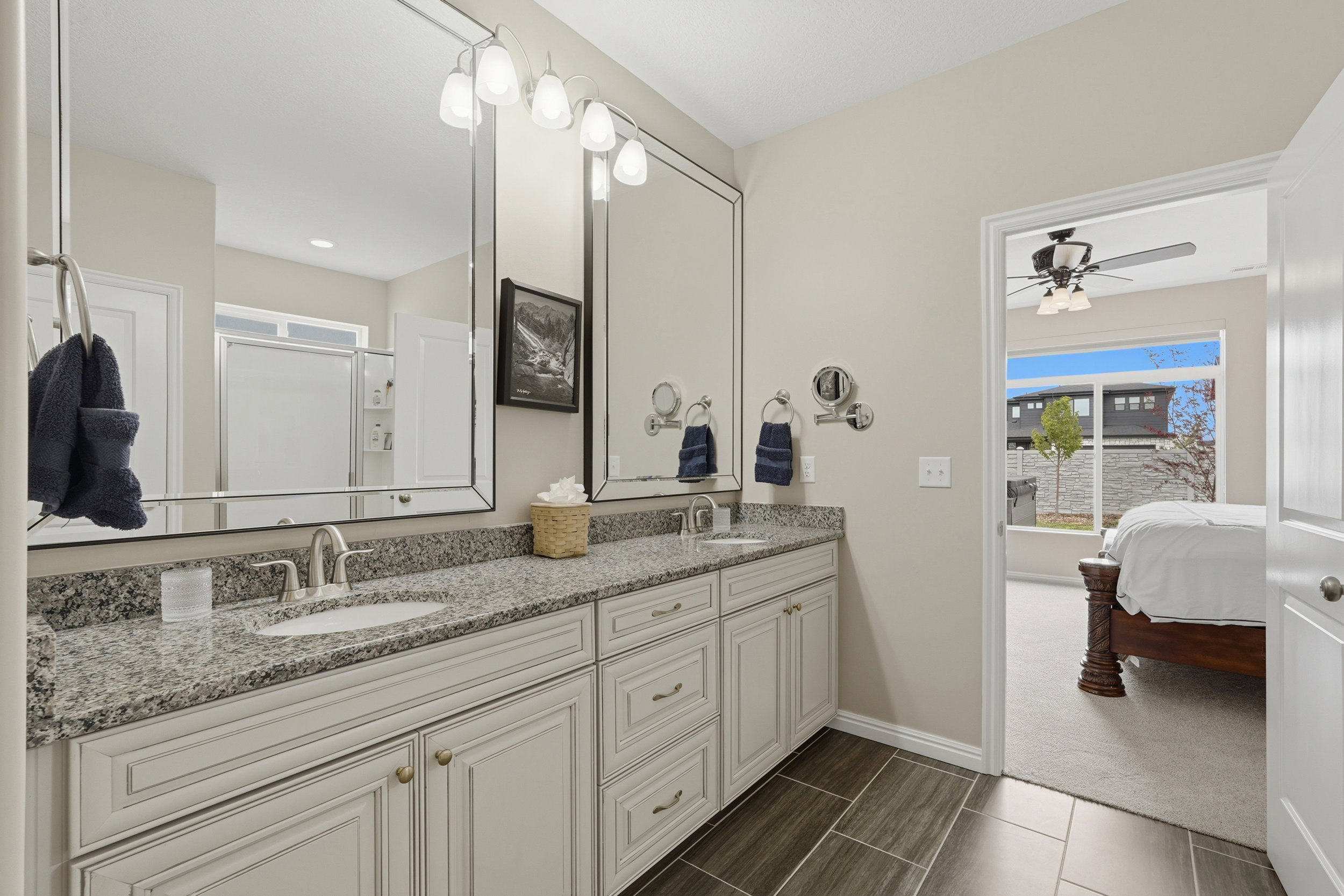 Ensuite bathroom with double vanity, a stall shower, dark carpet, and ceiling fan