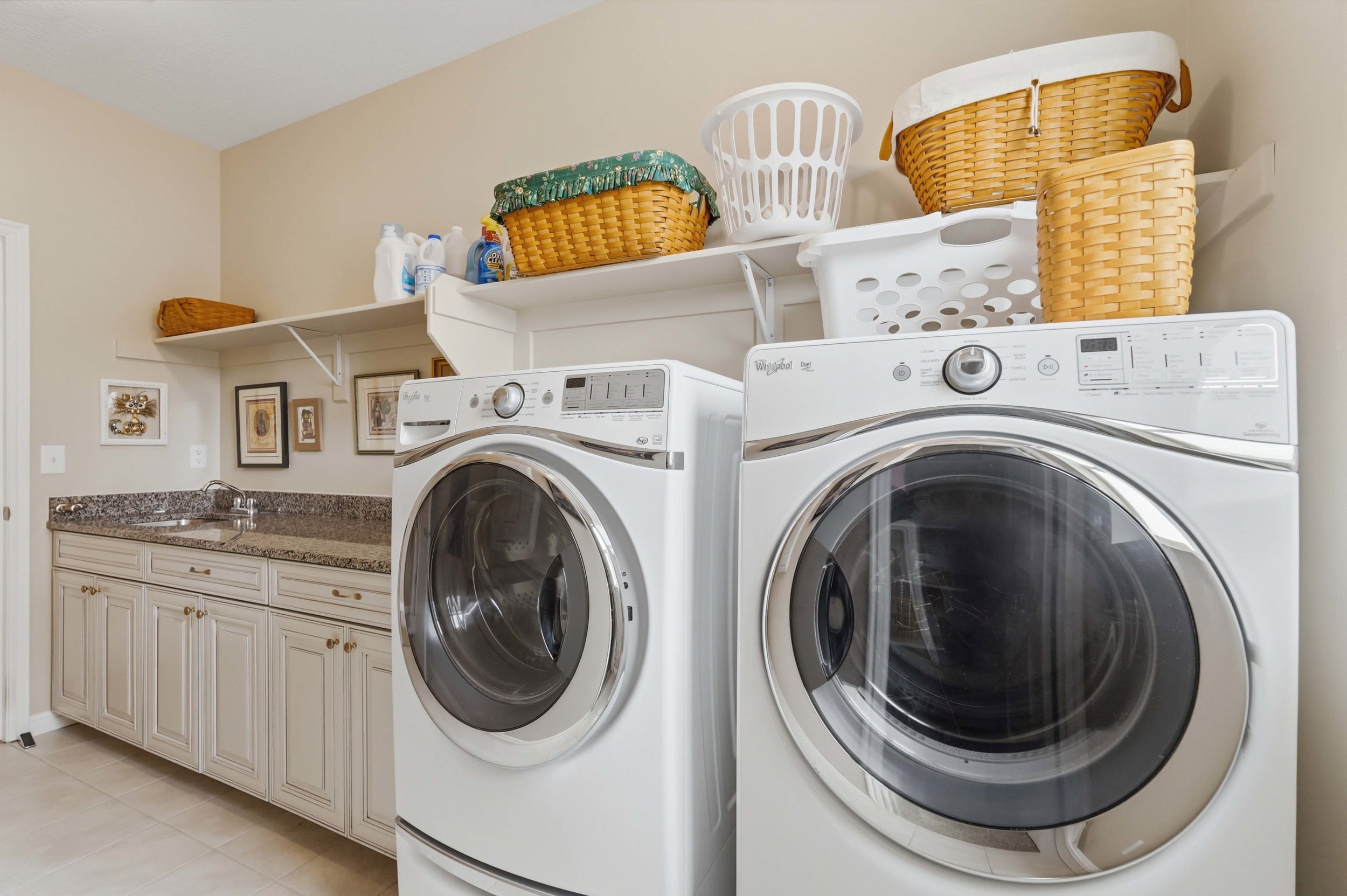 Laundry area with separate washer and dryer and light tile patterned floors