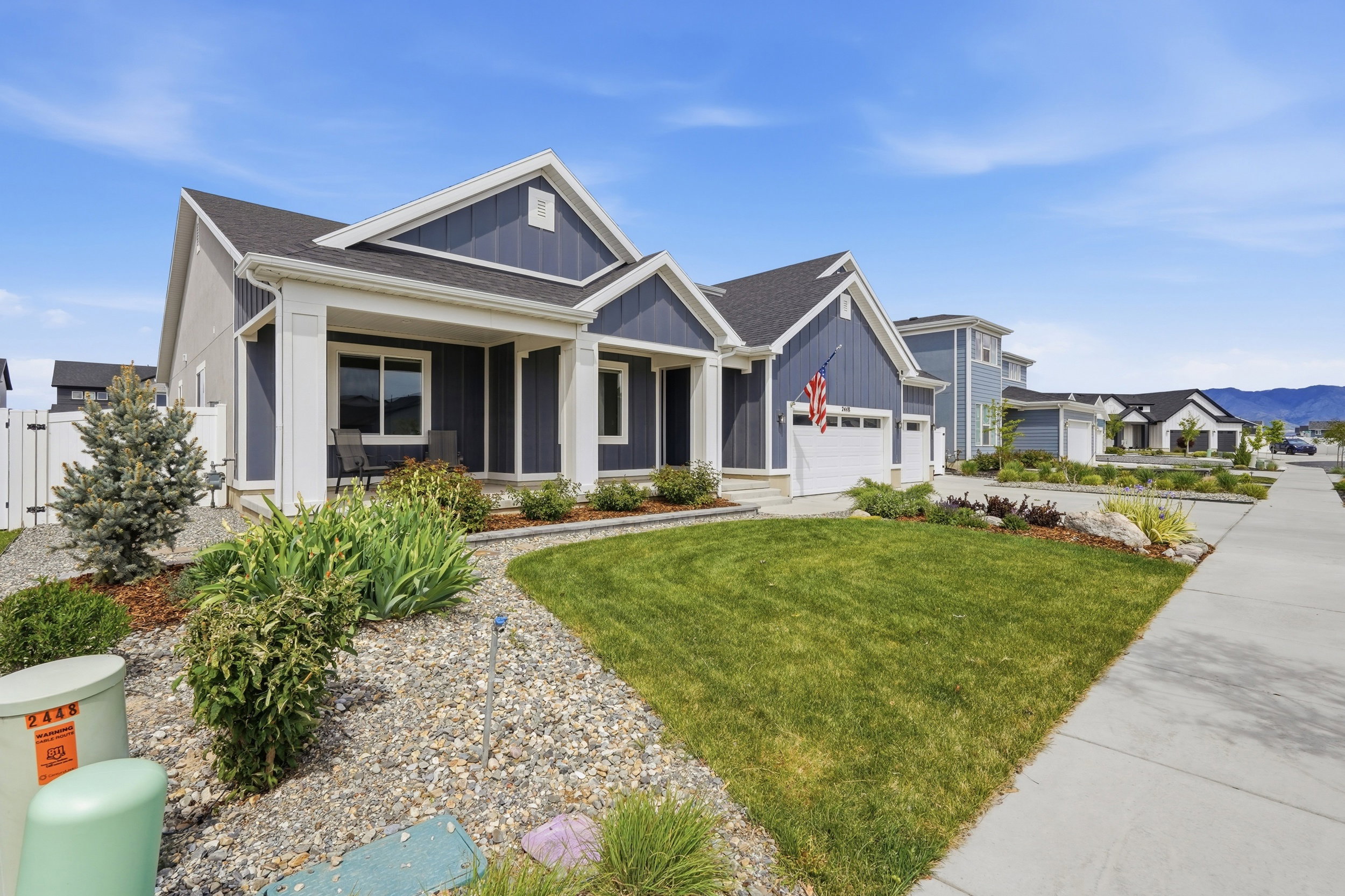 Craftsman house with board and batten siding, covered porch, a front lawn, roof with shingles, and concrete driveway