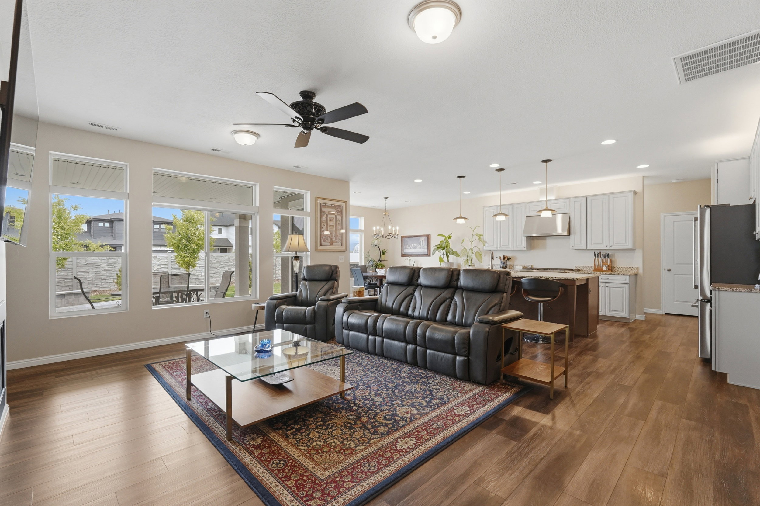 Living room with hanging lights, a ceiling fan, and dark wood-style flooring