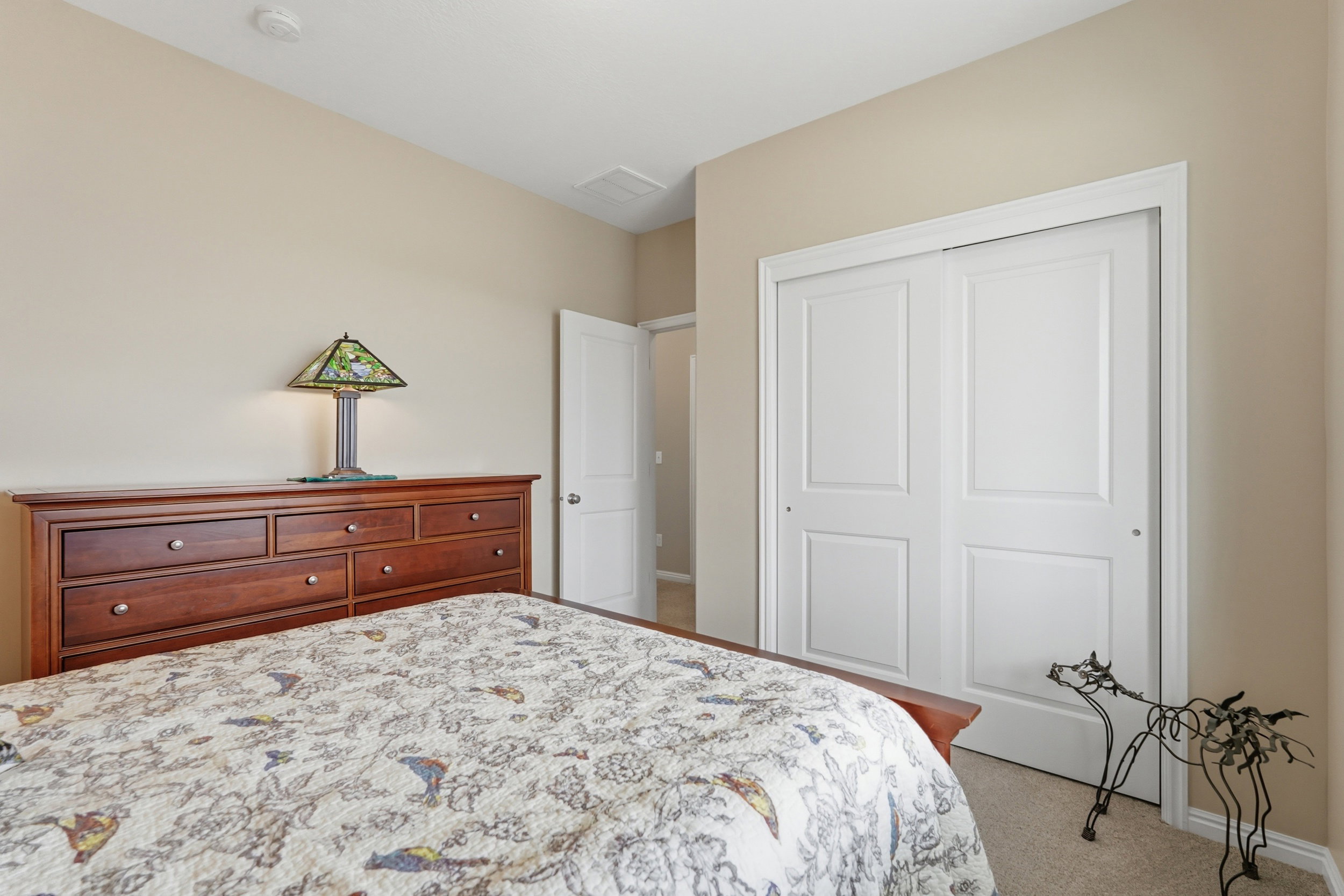 Bedroom with light colored carpet and a closet