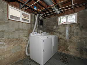 Laundry area with unfinished concrete flooring and washer and dryer