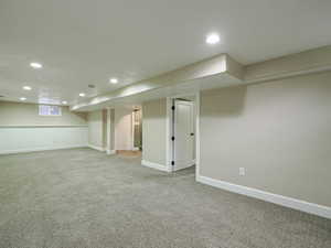 Finished below grade area with recessed lighting and light carpet