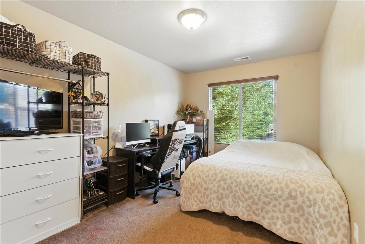 Bedroom with a desk and light colored carpet
