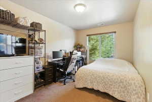 Bedroom with a desk and light colored carpet
