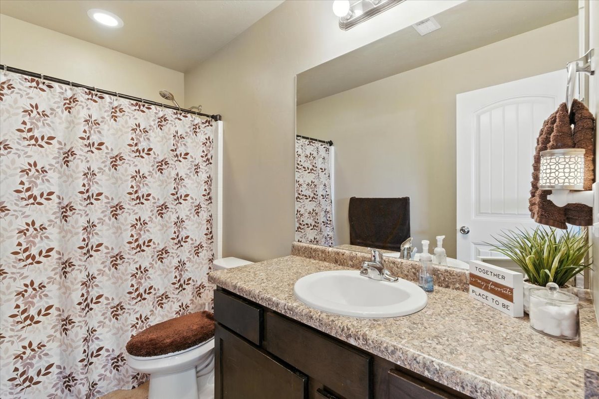 Full bath with vanity, a shower with shower curtain, and recessed lighting