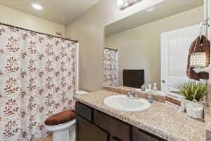 Full bath with vanity, a shower with shower curtain, and recessed lighting