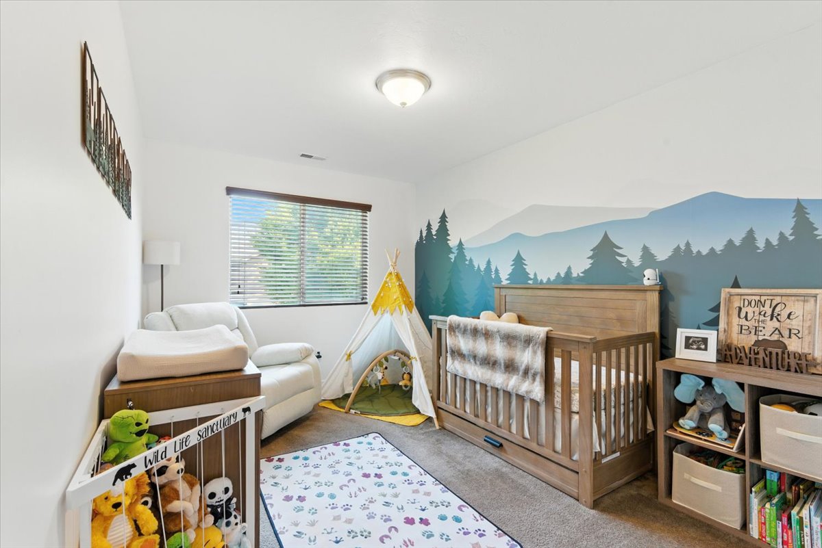 Bedroom with a crib and carpet floors
