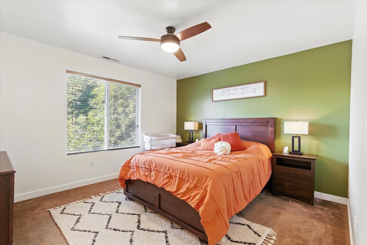 Carpeted bedroom featuring baseboards and ceiling fan