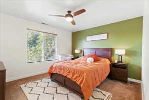 Carpeted bedroom featuring baseboards and ceiling fan