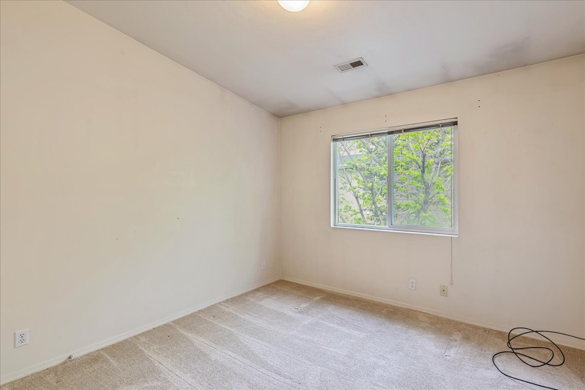 Spare room featuring light colored carpet and baseboards