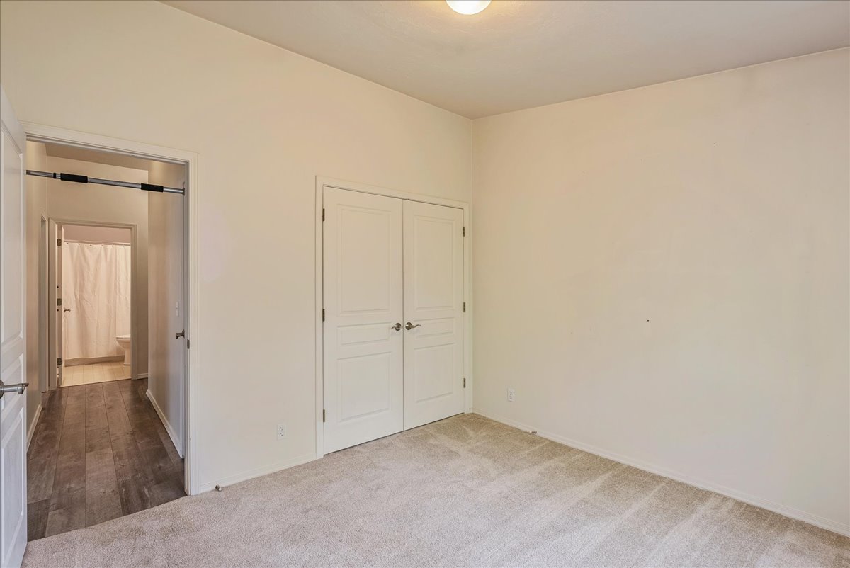 Unfurnished bedroom with light carpet and a closet