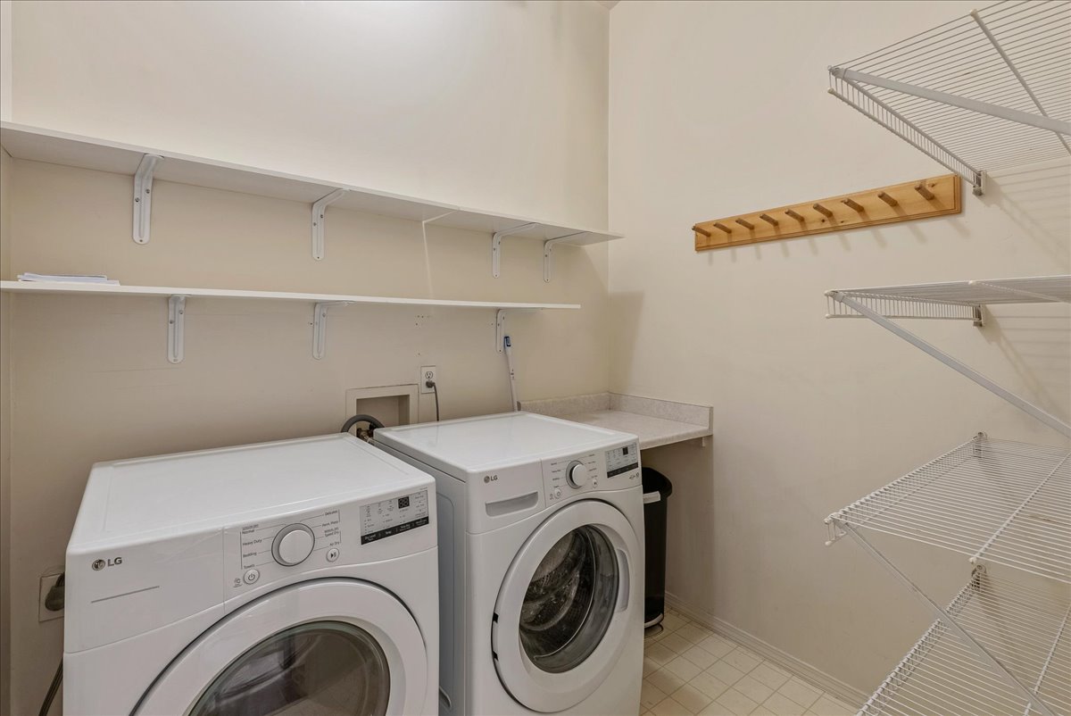 Laundry room featuring washing machine and dryer and baseboards