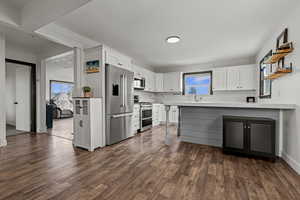 Kitchen with a peninsula, open shelves, and dual tone cabinetry