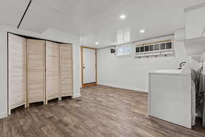 Laundry area with wood like laminate floors, recessed lighting and an exterior door