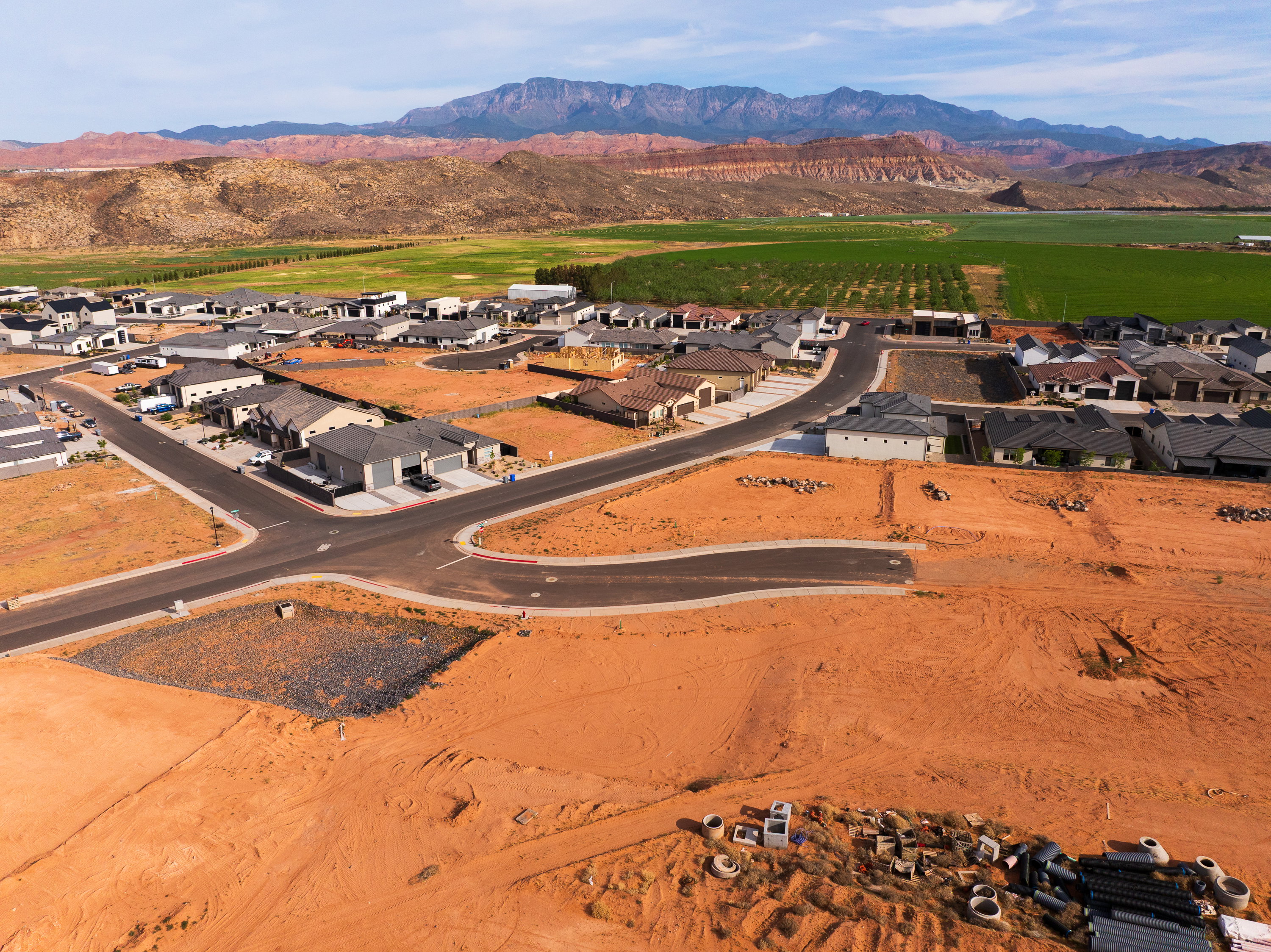 Aerial view of property and surrounding area featuring a mountainous background and nearby suburban area