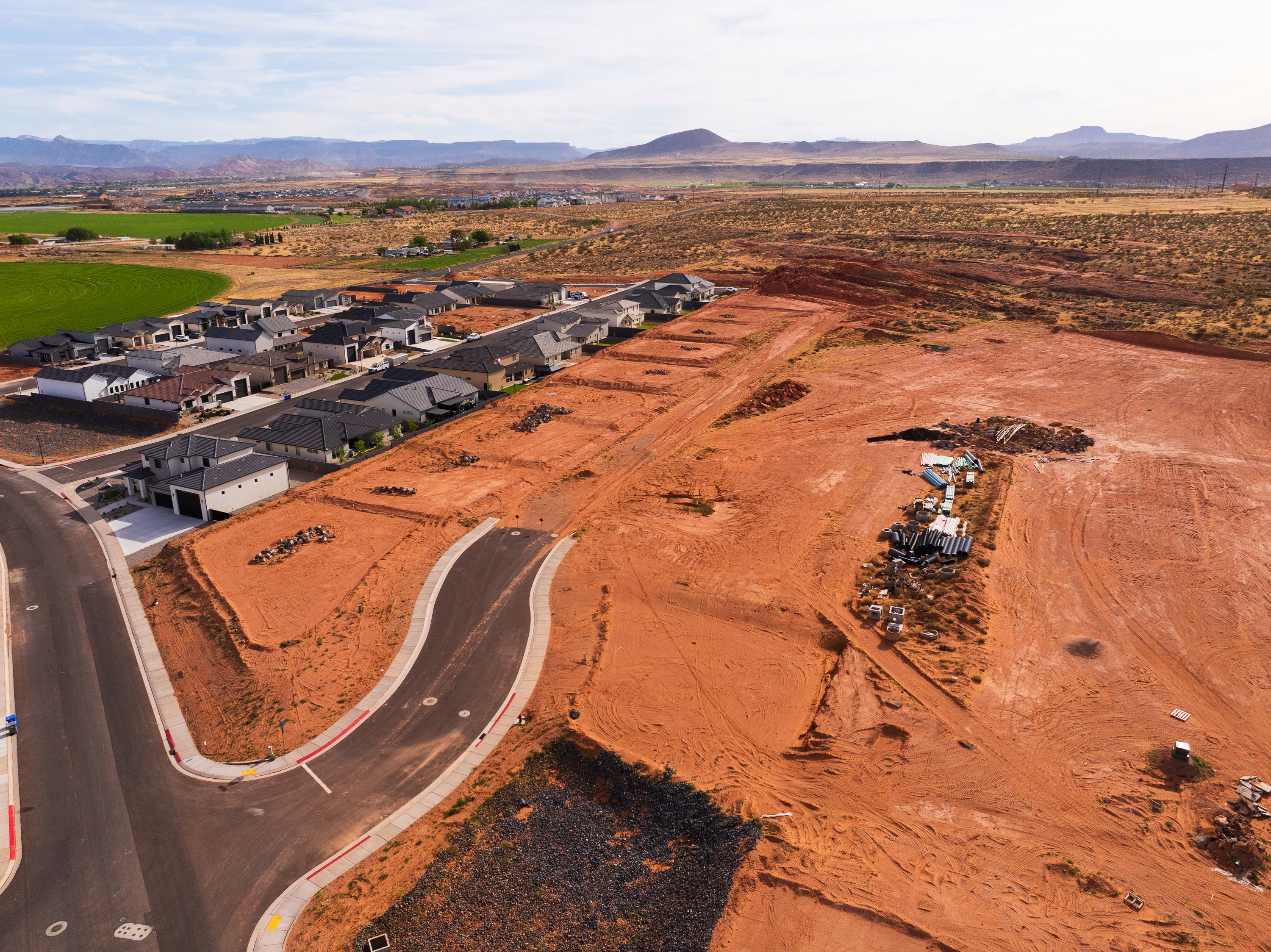 Aerial view of sparsely populated area featuring a mountainous background and nearby suburban area