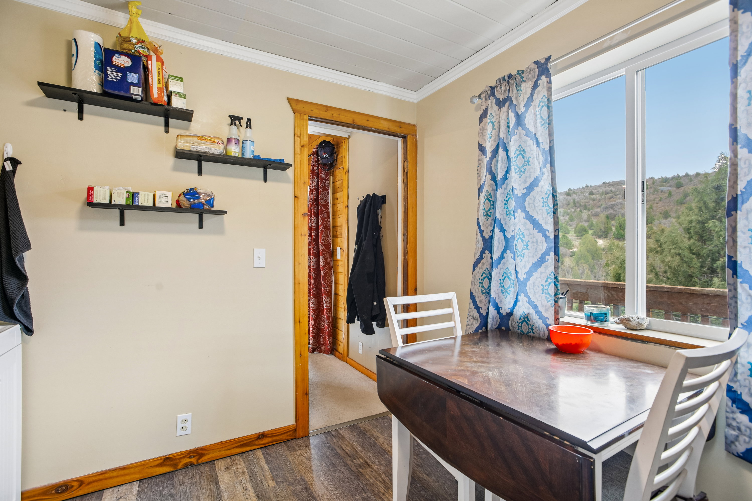 Dining space with wood finished floors and crown molding