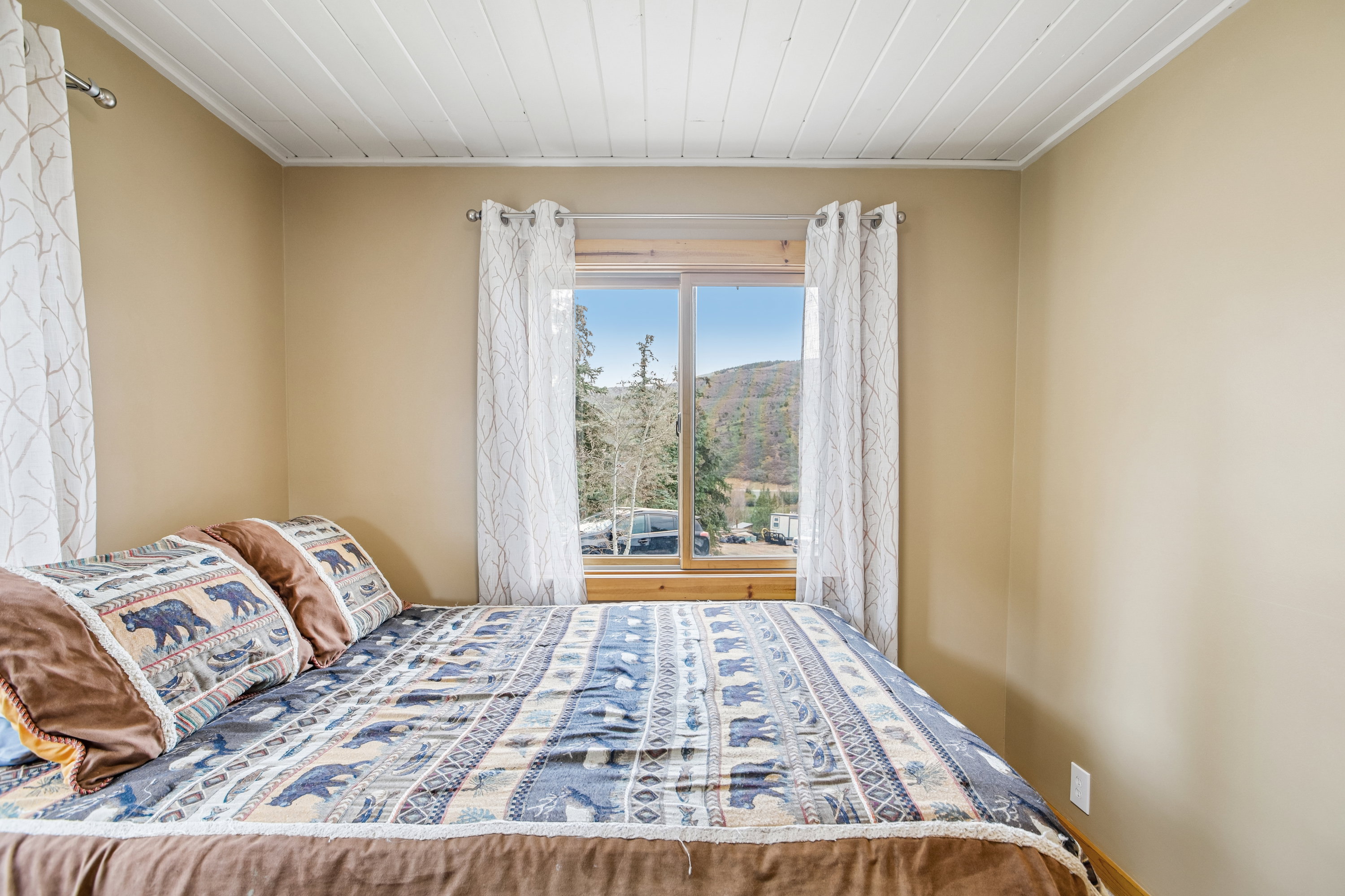 Bedroom featuring wooden ceiling and a mountain view