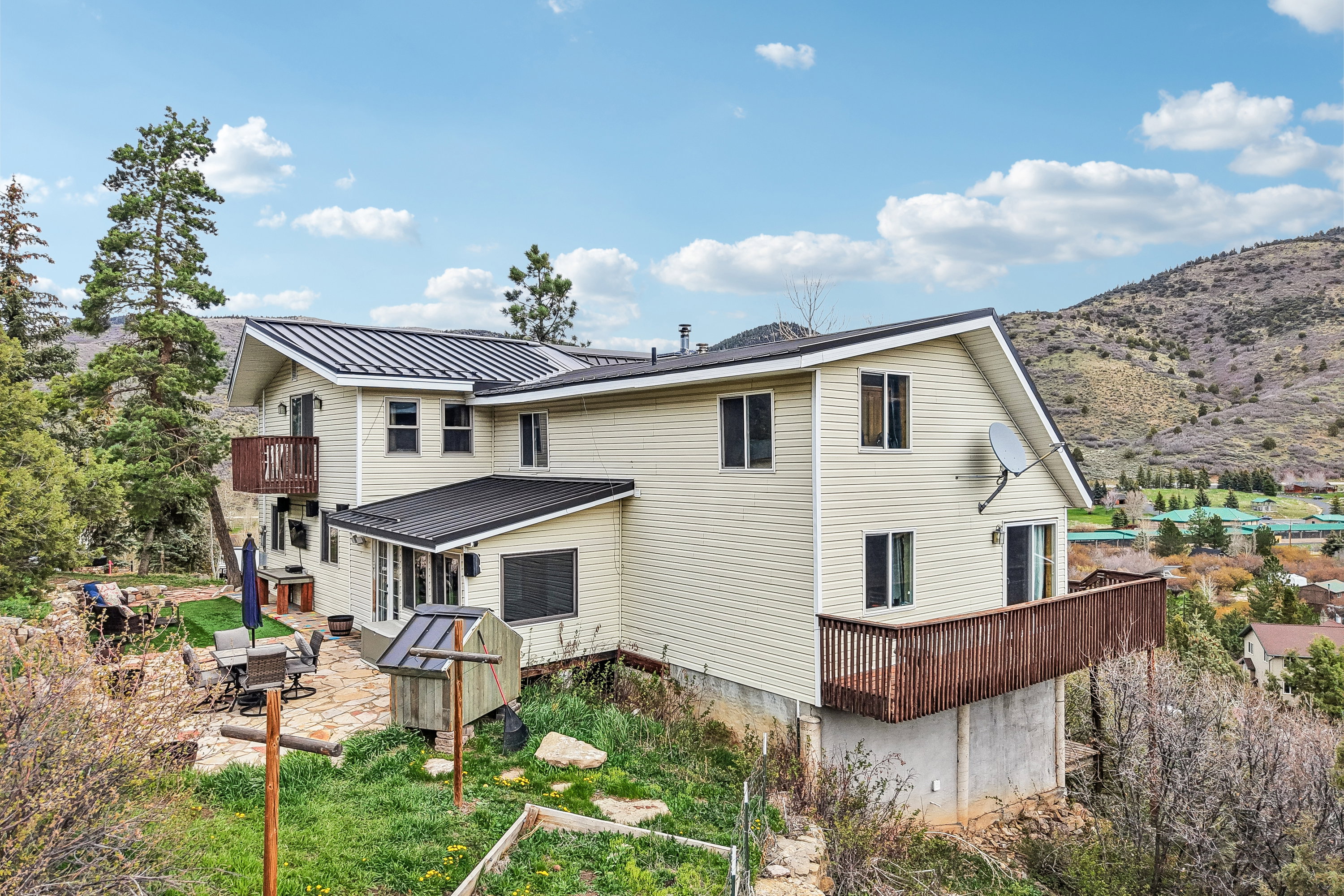 Back of property featuring a patio area, a balcony, and a standing seam roof