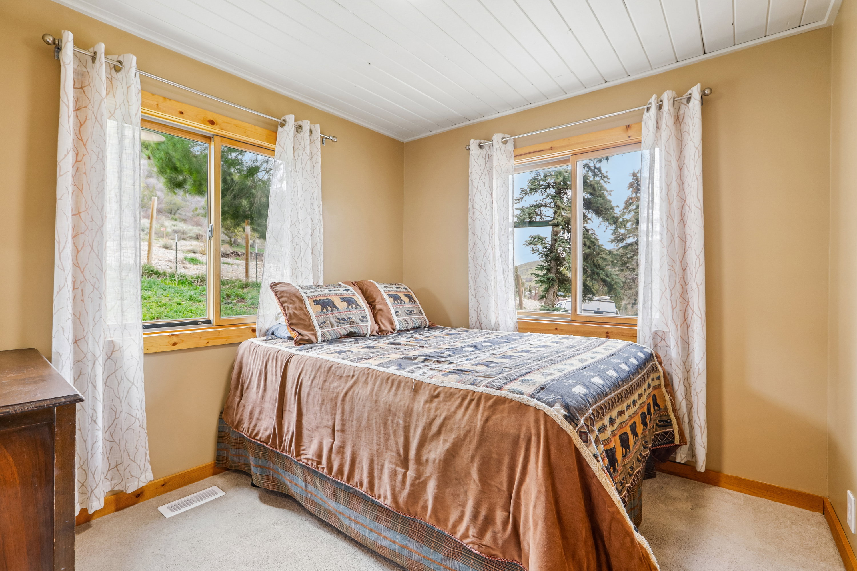 Bedroom with wooden ceiling and light colored carpet