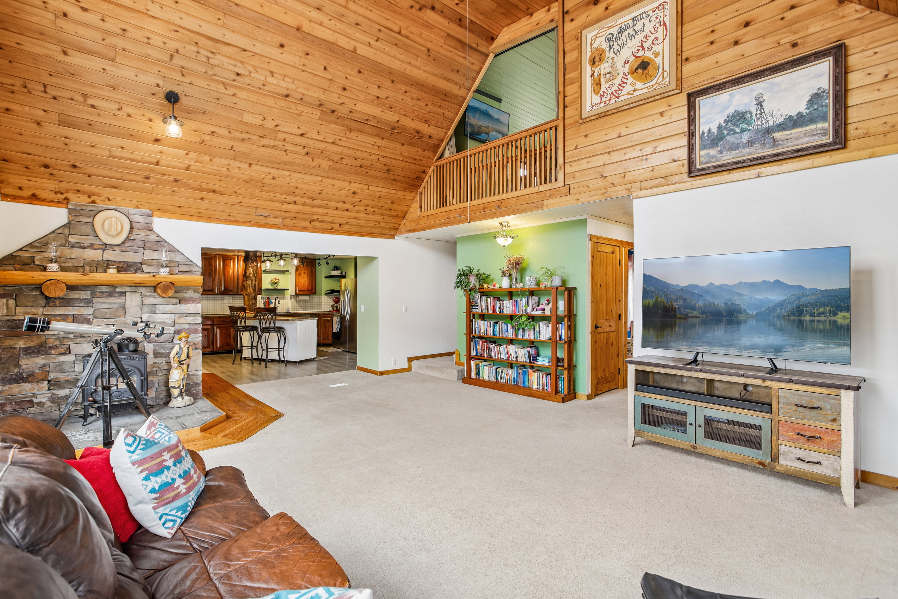 Living area with carpet and a vaulted wood ceiling