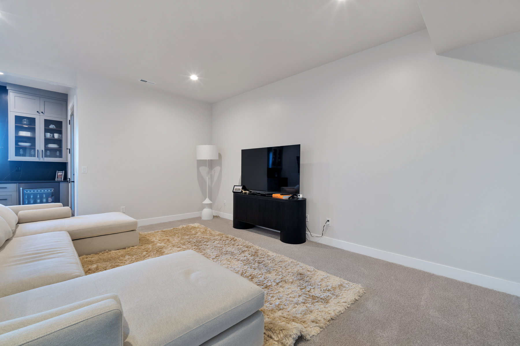 Living room with light colored carpet and recessed lighting