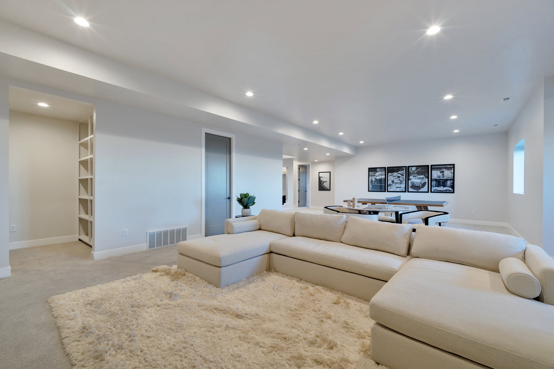Living area with light colored carpet and recessed lighting
