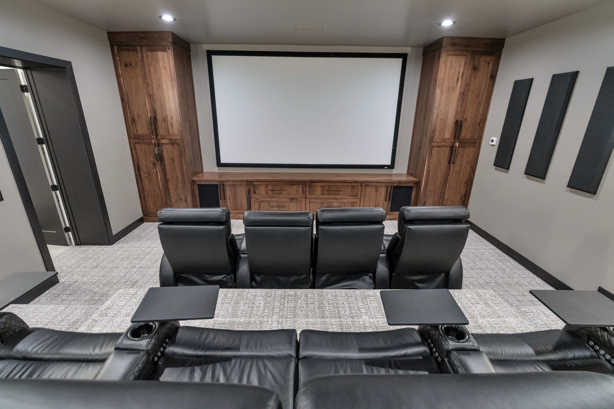 Cinema room featuring light colored carpet and baseboards