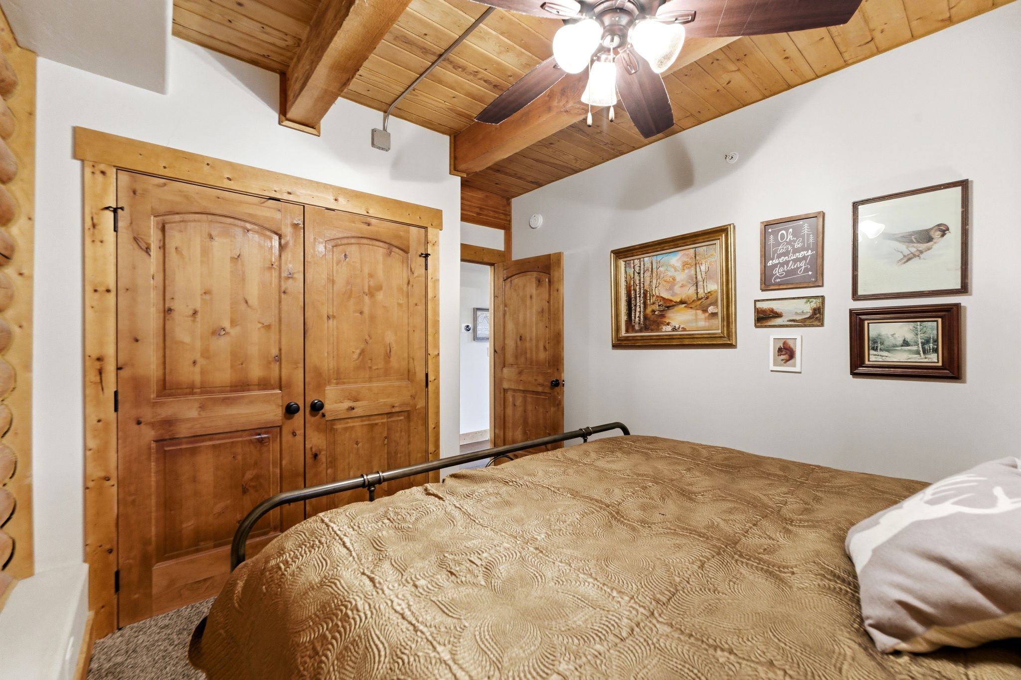 Unfurnished bedroom featuring a closet, a ceiling fan, and a wooden ceiling with exposed beams