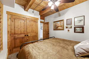Unfurnished bedroom featuring a closet, a ceiling fan, and a wooden ceiling with exposed beams