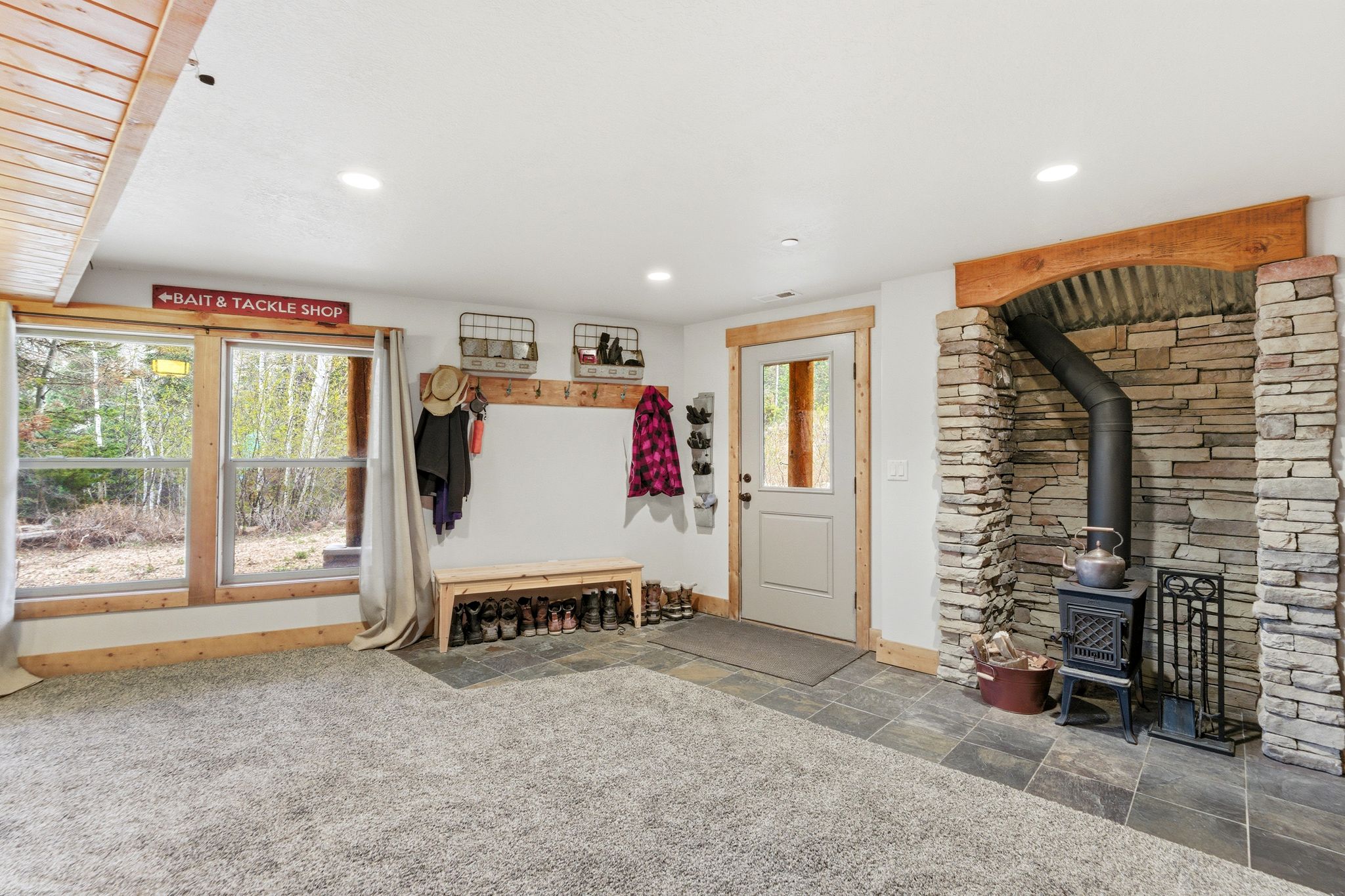 Mudroom with stone tile flooring, a wood stove, and recessed lighting