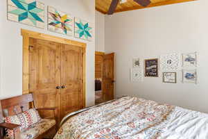 Bedroom with a closet, a high wood ceiling, and a ceiling fan