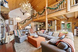 Living area with a high wooden ceiling, suspended lighting, wooden walls, french doors, and hardwood / wood-style floors